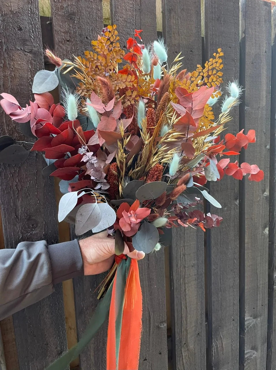 Autumn-toned dried-flower bridal bouquet with long ribbons